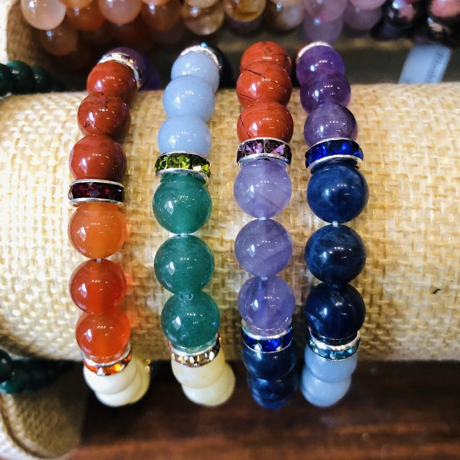 Ce bracelet est fabriqué aux couleurs des 7 chakras avec ces minéraux: améthyste, sodalite, angélite, aventurine verte, aventurine jaune, cornaline et jaspe rouge. Les perles sont séparées par des anneaux en métal avec des cristaux de verre.*